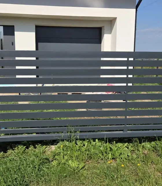 Palisadowa brama przesuwna w kolorze grafitowym przed garażem domu w Nysie