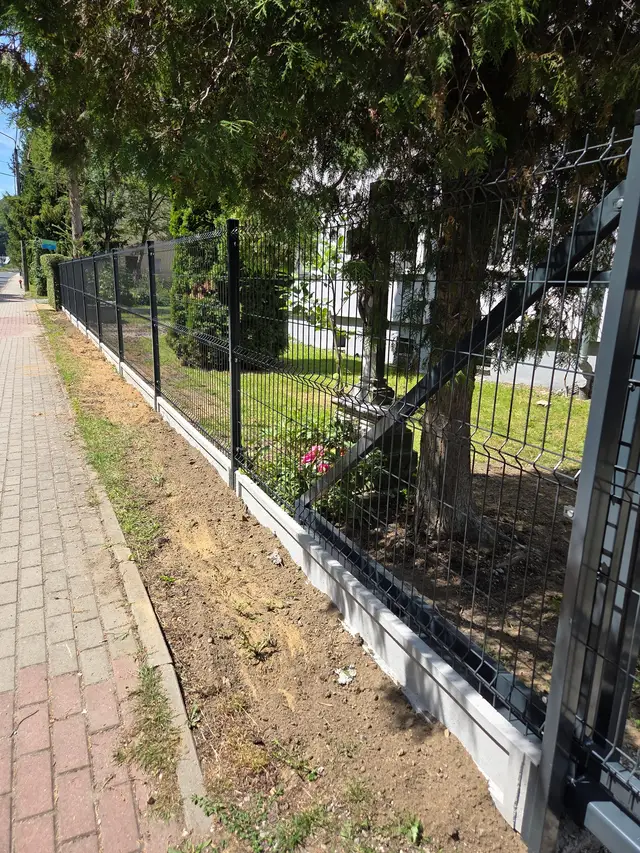 Ogrodzenie panelowe w kolorze grafitowym na gładkiej podmurówce wzdłuż chodnika, Burgrabice