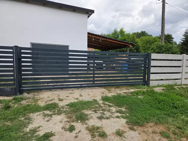 Ogrodzenie palisadowe z poziomych profili w kolorze grafitowym z bramą, okolice Nysy