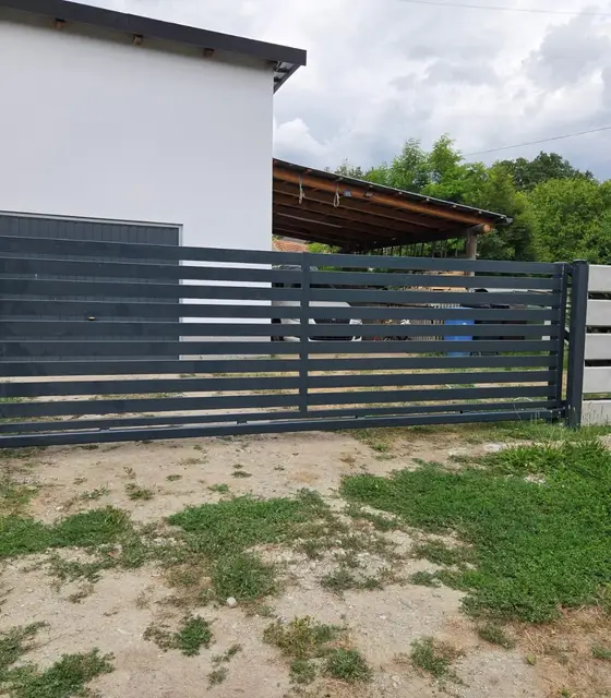 Ogrodzenie palisadowe z poziomych profili w kolorze grafitowym z bramą