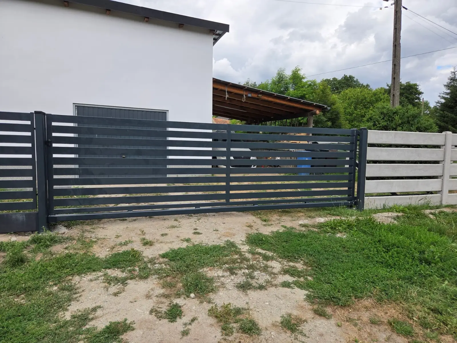 Ogrodzenie palisadowe z poziomych profili w kolorze grafitowym z bramą, okolice Nysy
