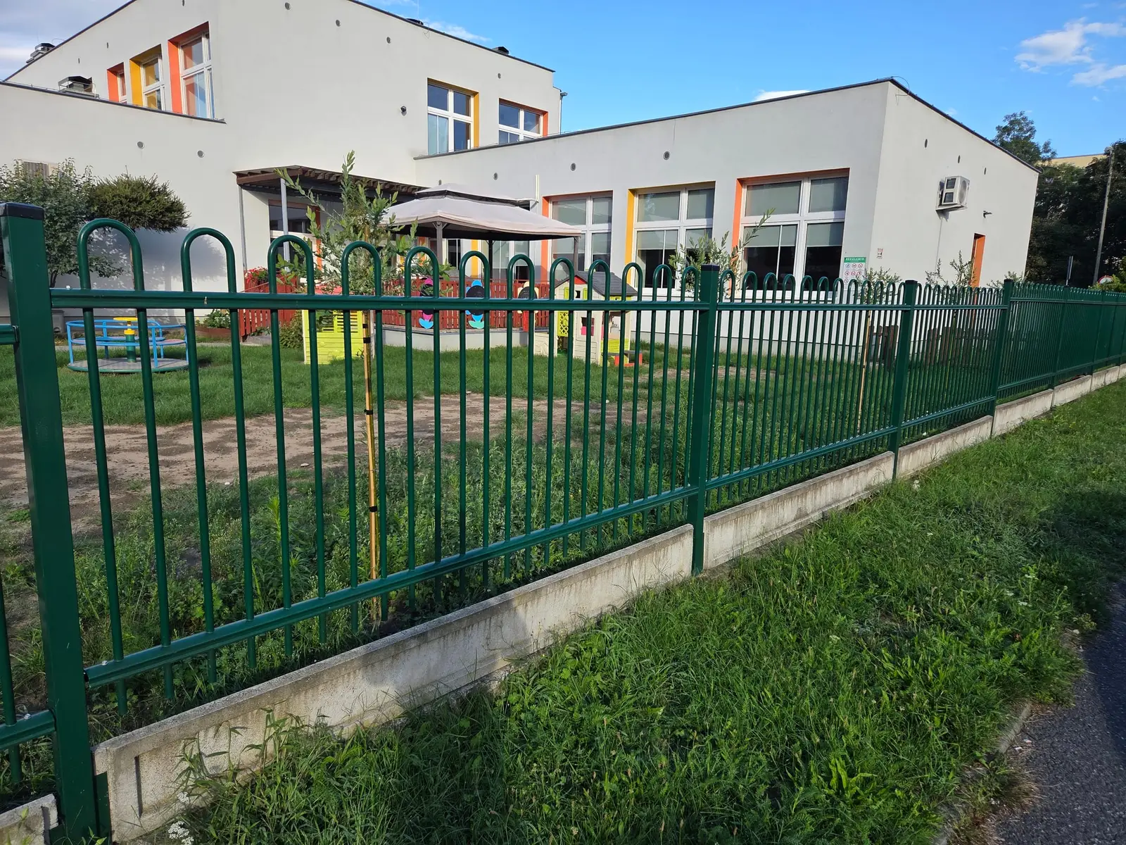 Zielone ogrodzenie ozdobne na betonowej podmurówce przy Żłobku Miejskim nr 2 w Nysie